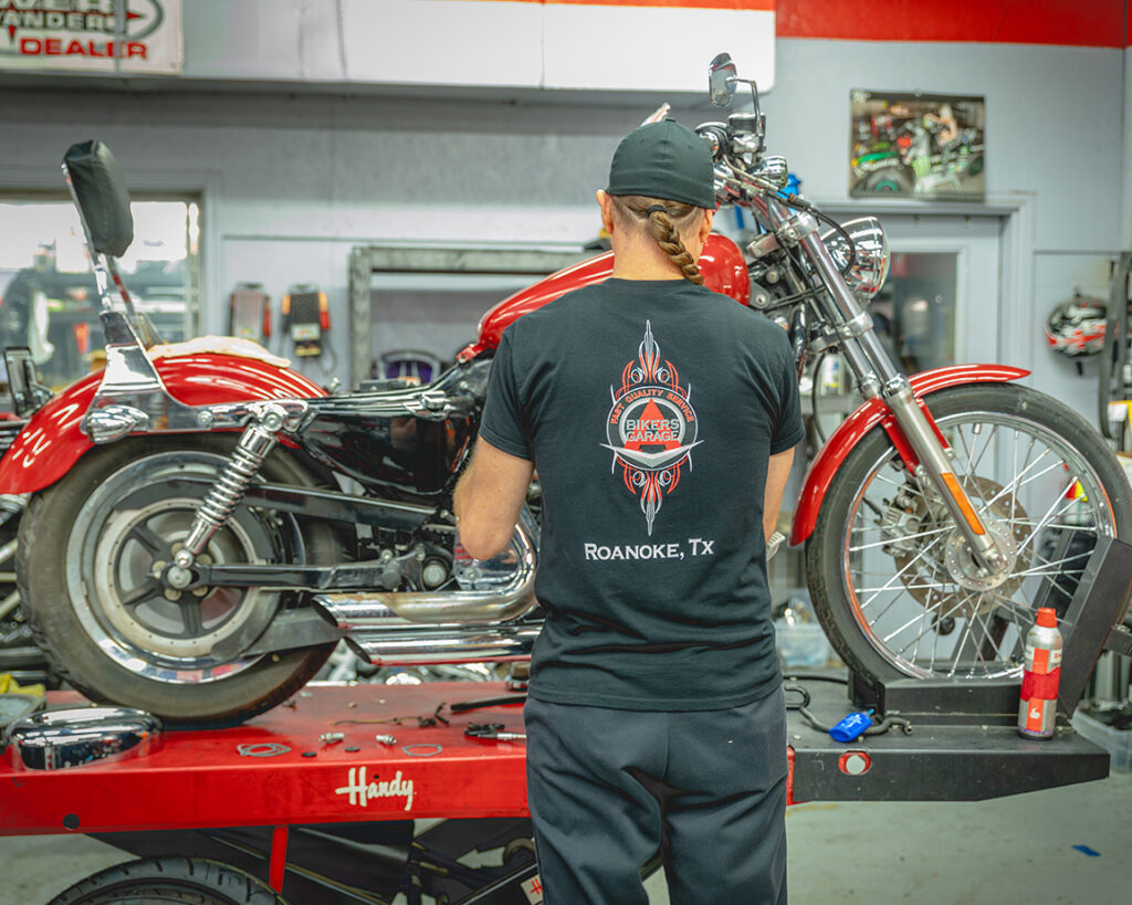 A mechanic work on a red motorcycle