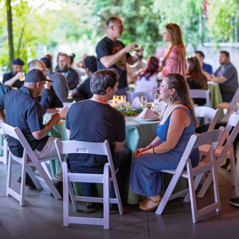 a varied group of professionals seated at a corporate event outdoors.