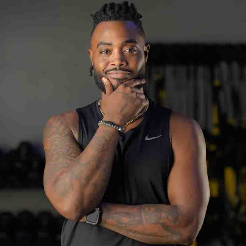 fitness-instructor-photography-portraits-dallas-fort-worth a black man wearing a black tank top with his right hand to his chin