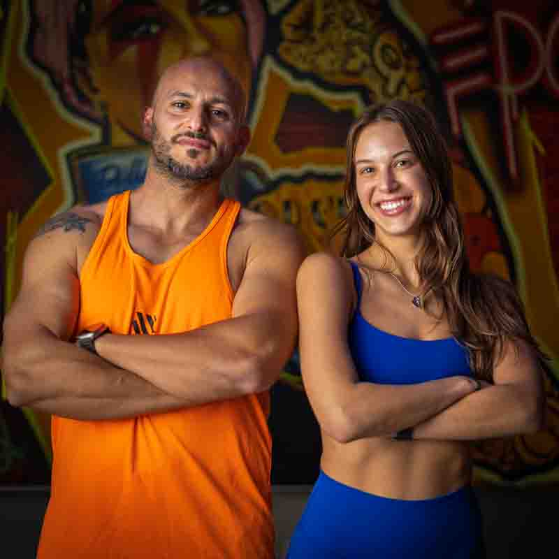 fitness-photography-portraits-dallas-fort-worth a man and a woman smiling at the camera and standing with the arms crossed.